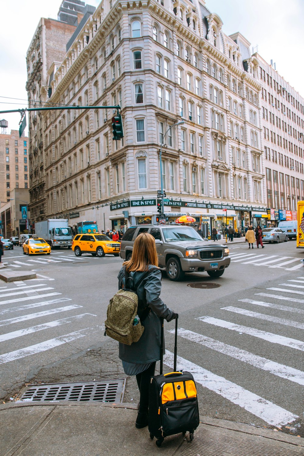 woman in black jacket standing on pedestrian lane during daytime