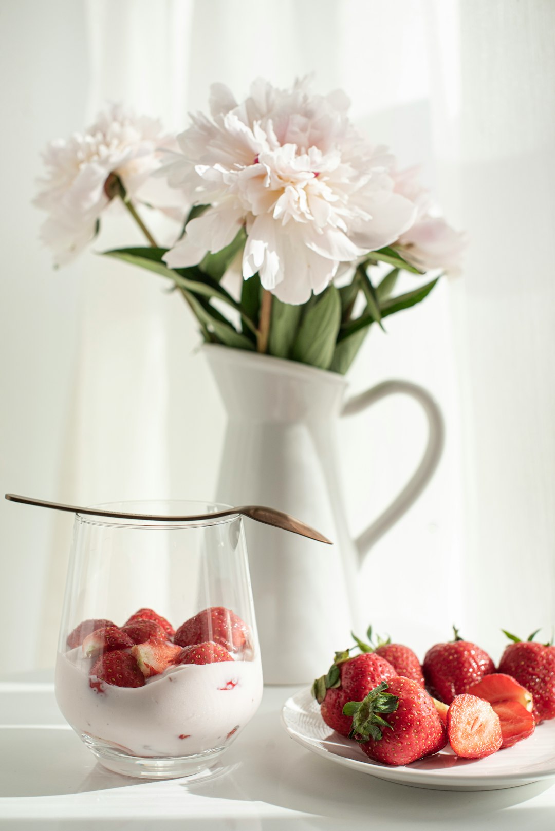 white and red flowers in white ceramic vase