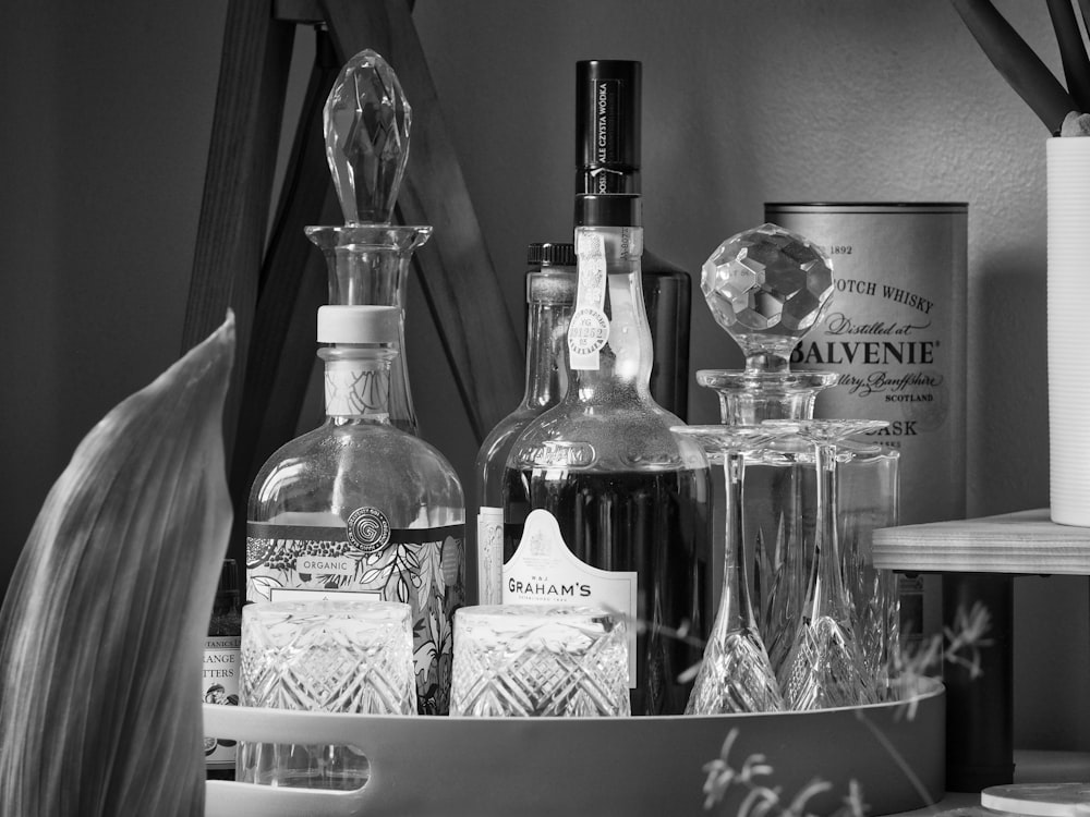 grayscale photo of glass bottles