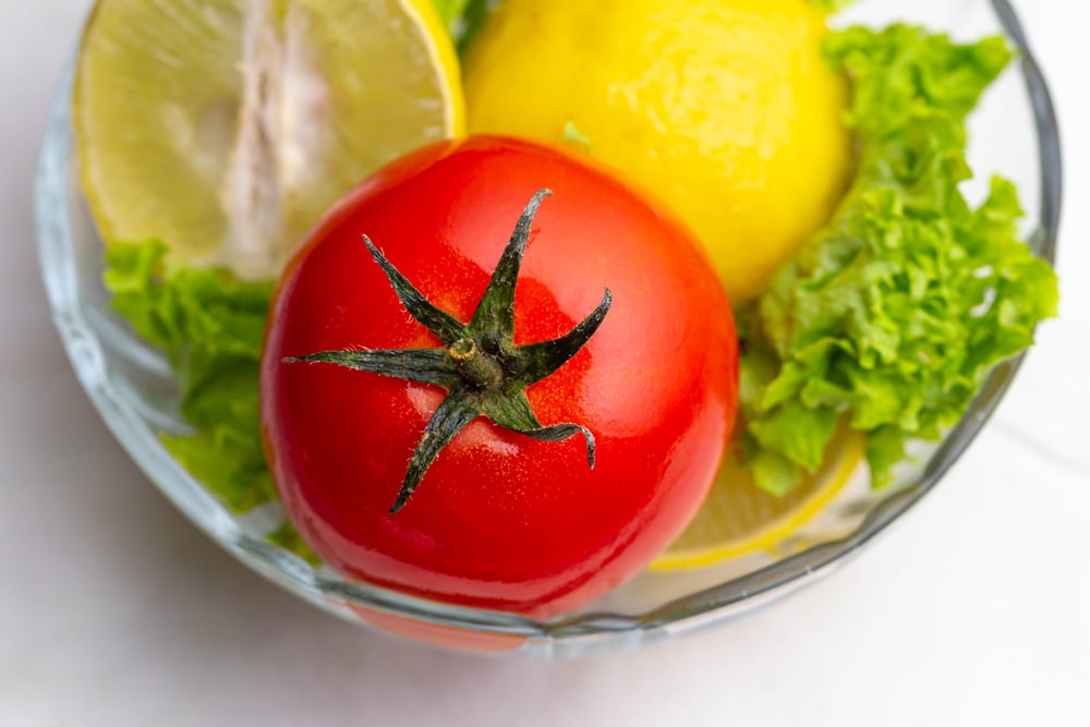 red tomato on clear glass bowl