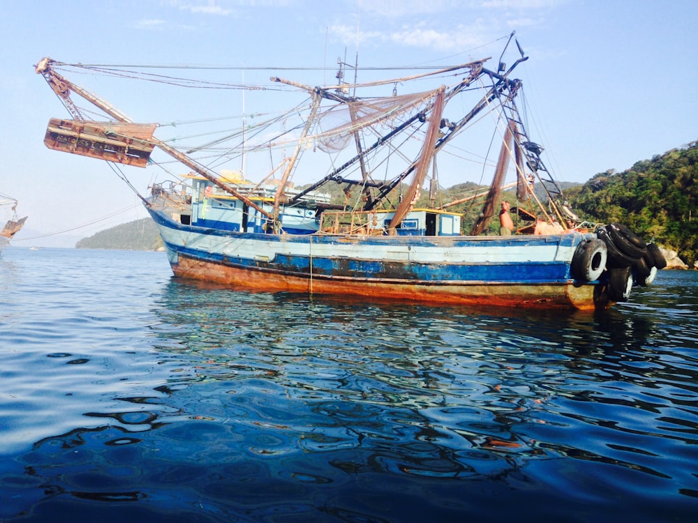 brown and white boat on water during daytime