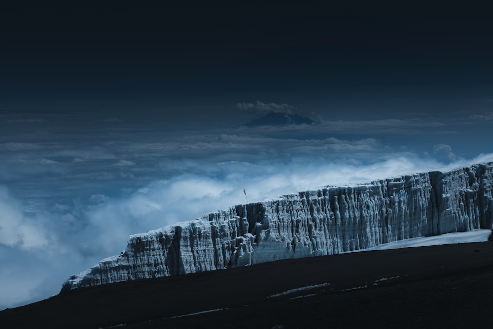 white clouds over snow covered mountain