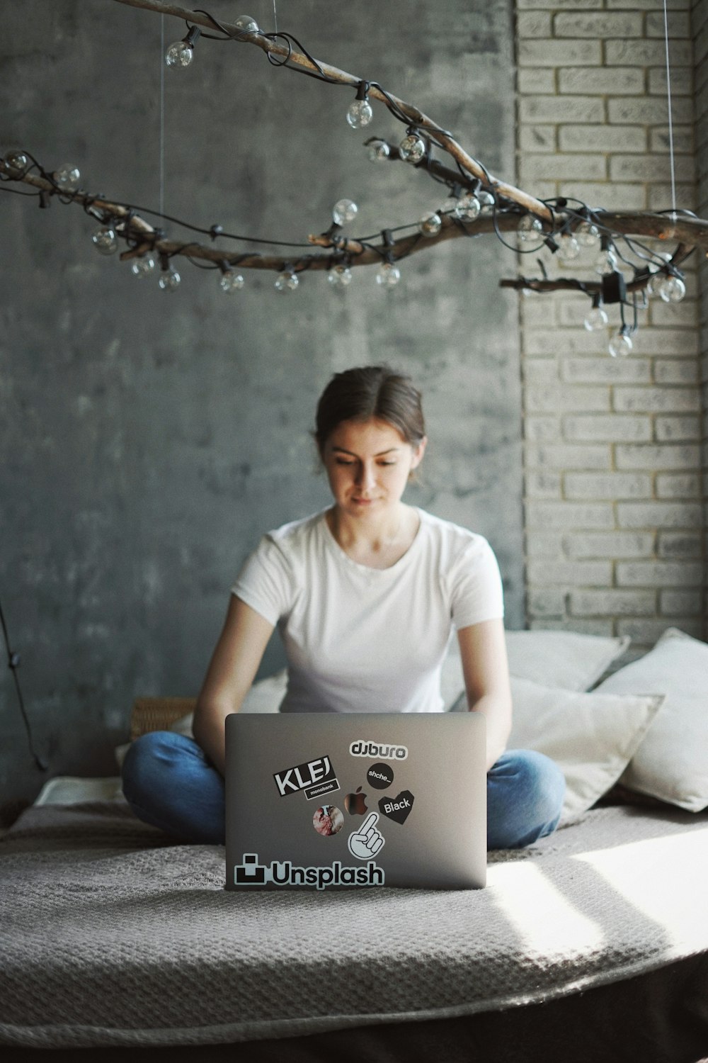 woman in white crew neck t-shirt sitting on bed