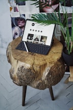 A rustic wooden table with Mediterranean food ingredients and a laptop.