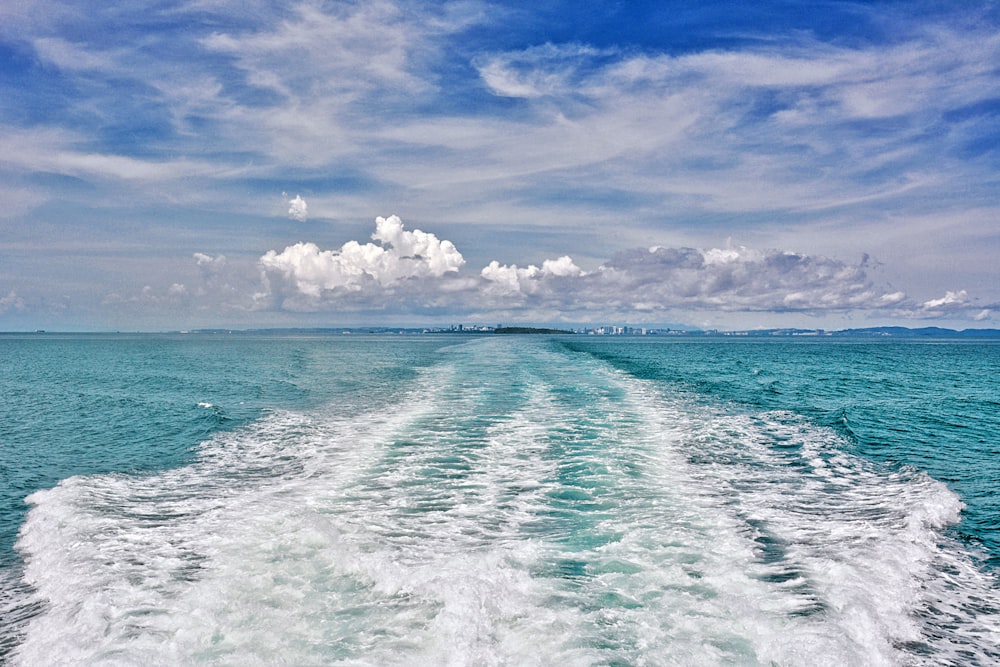 blue ocean under blue and white cloudy sky during daytime