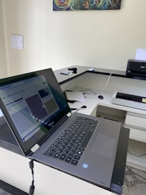 Close-up of high-end laptops and printers ready for rental in a neat office space.