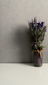 purple flowers in brown ceramic vase