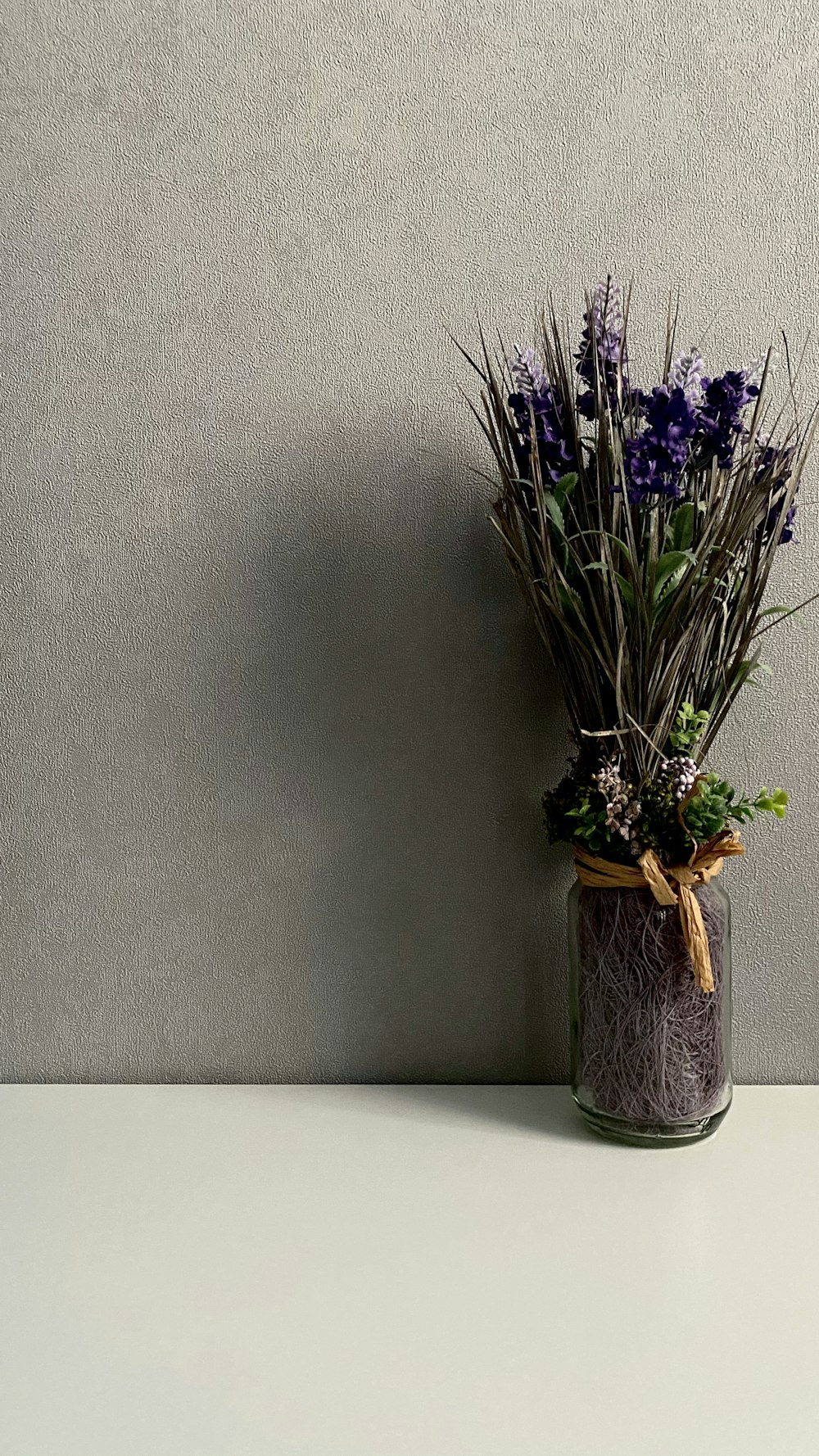 purple flowers in brown ceramic vase