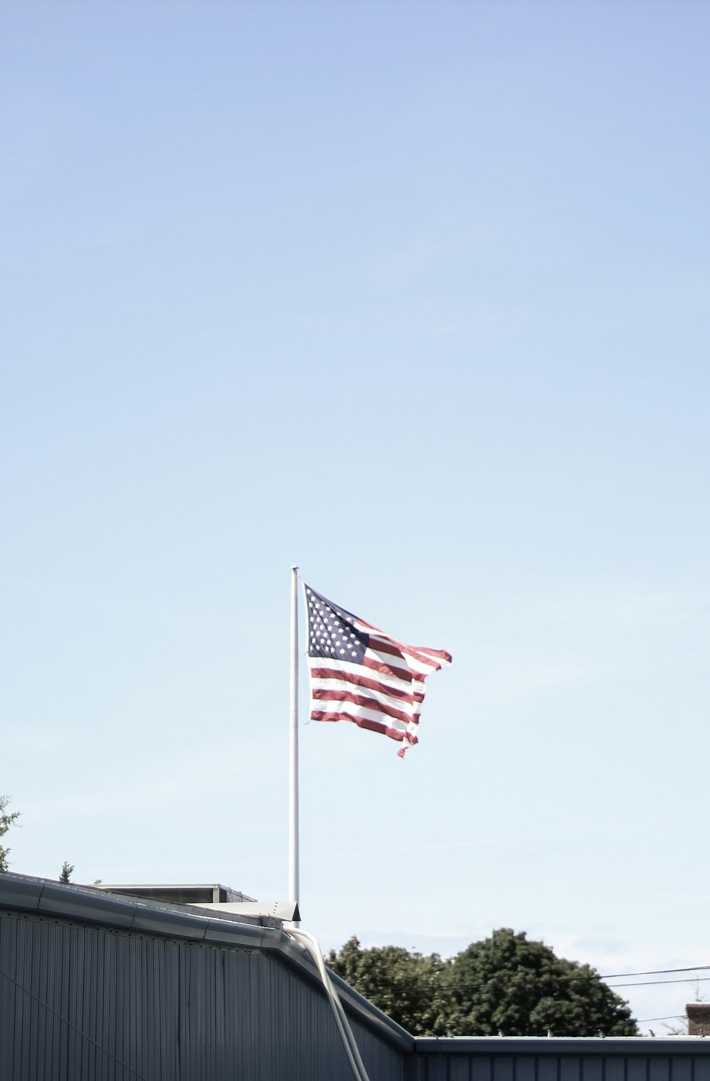 us flag on pole during daytime