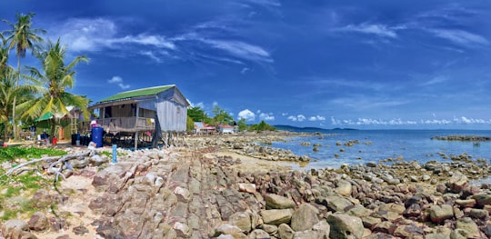 white wooden house near body of water during daytime in Koh Rong Cambodia
