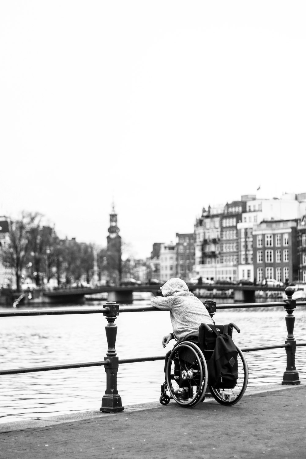 Foto en escala de grises de hombre montando en bicicleta en el puente