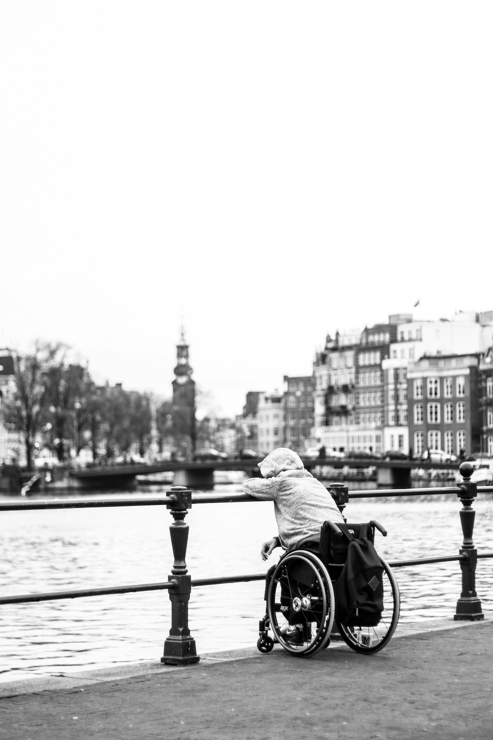 Foto in scala di grigi dell'uomo che va in bicicletta sul ponte