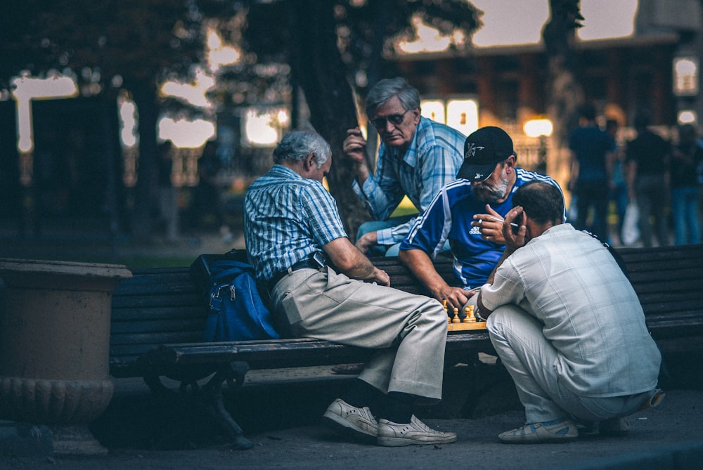 man in blue and white plaid dress shirt sitting on bench