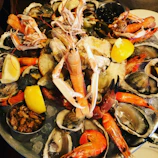 Fresh seafood platter served on a seaside terrace overlooking Kotor Bay.