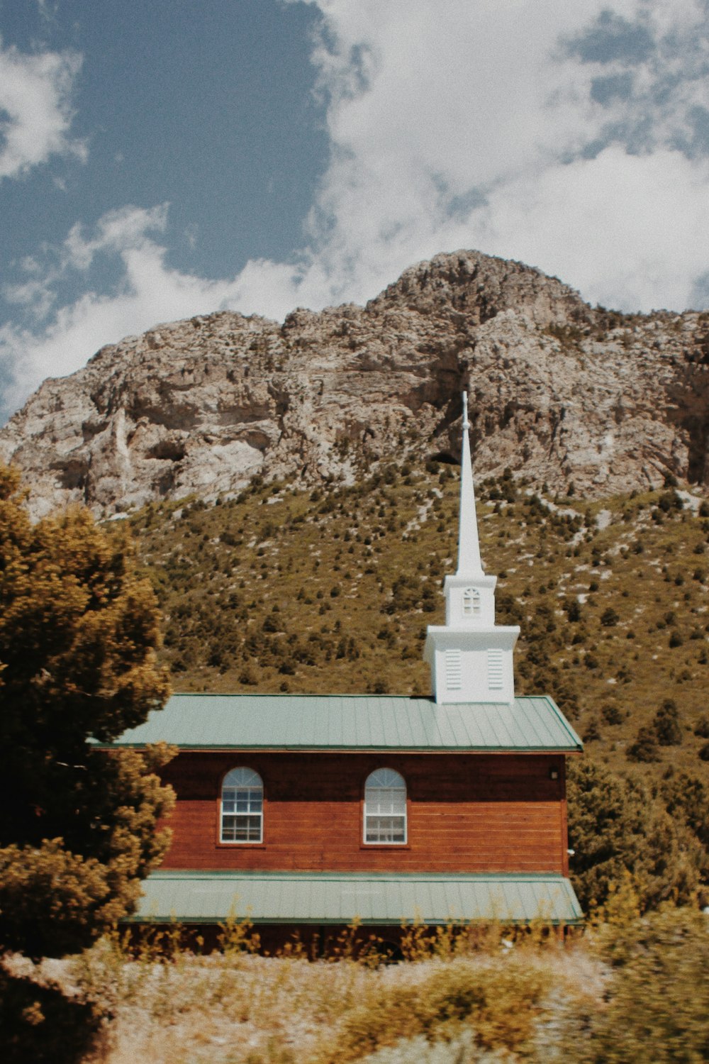 white and brown concrete church near brown mountain under blue sky during daytime