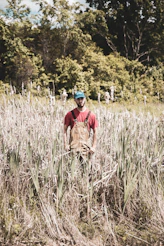 man in brown shirt and blue helmet standing on green grass field during daytime