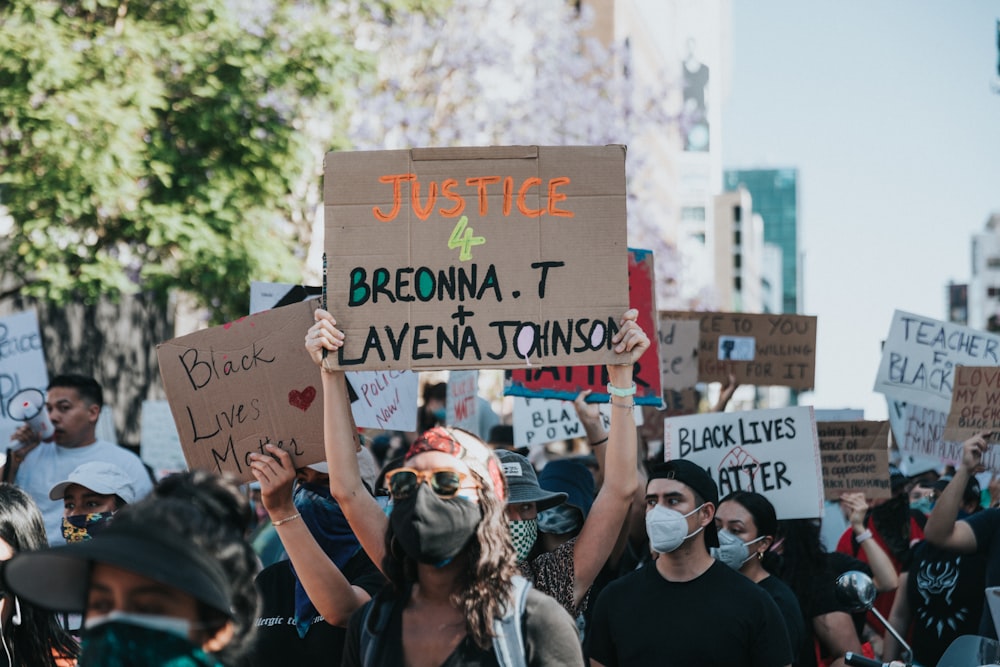 people holding a signage during daytime