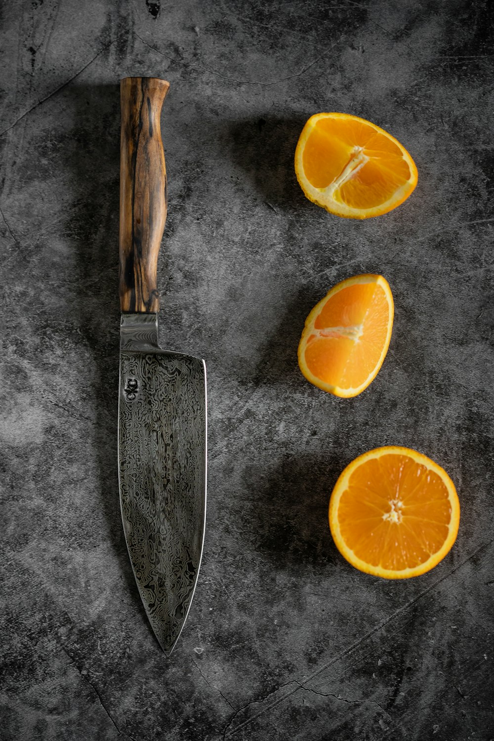 スライスしたオレンジ色の果物と黒い柄のナイフ