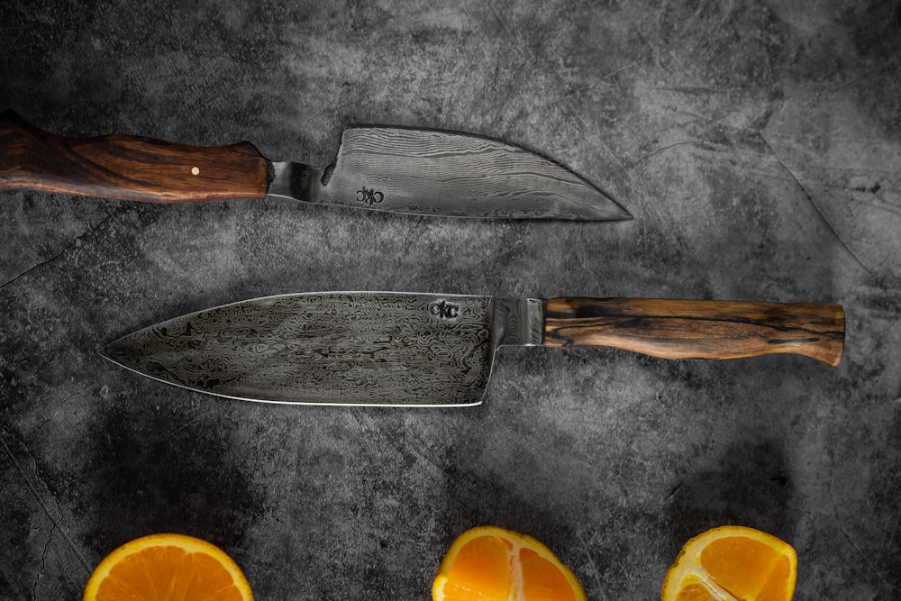 stainless steel bread knife beside orange fruits