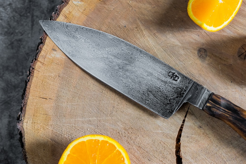 sliced orange fruit beside stainless steel knife