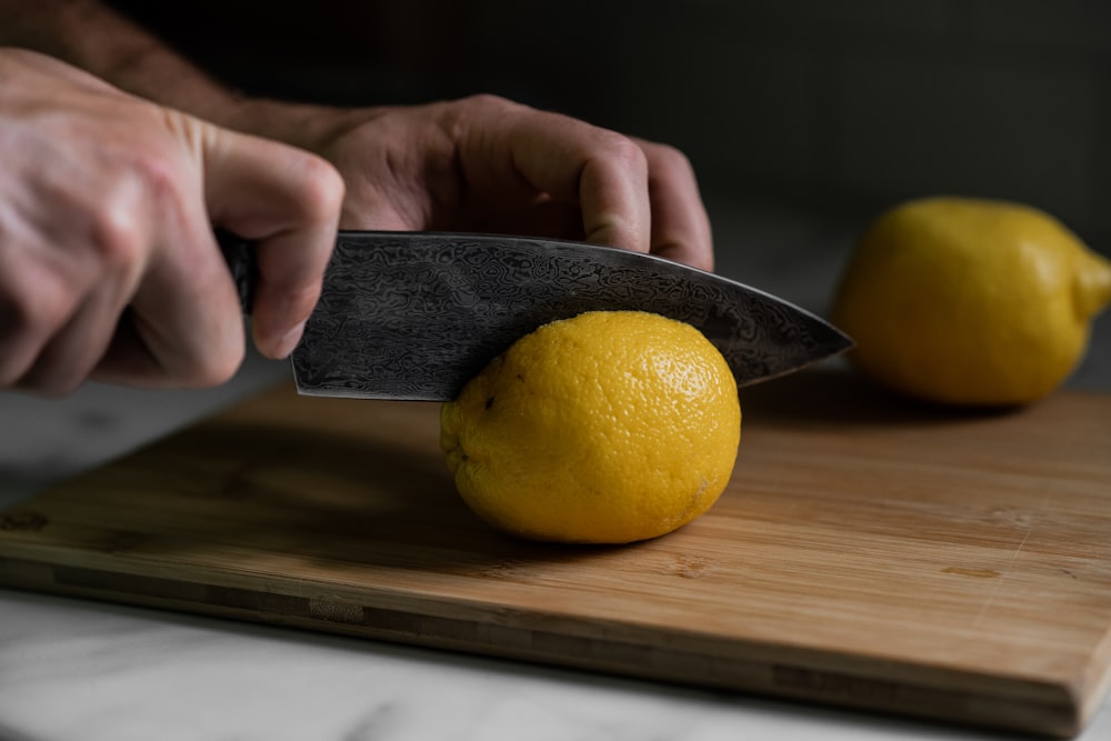 person holding yellow lemon fruit