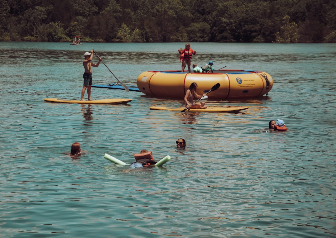 people riding orange kayak on body of water during daytime