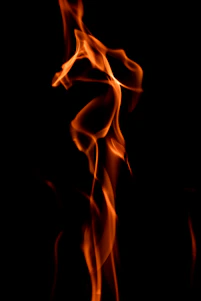 A solemn memorial flame flickering against a dark background, symbolizing remembrance and resilience.