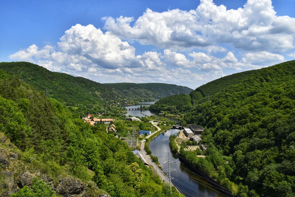 green trees and houses under blue sky and white clouds during daytime