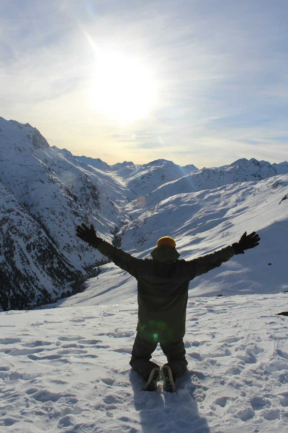 man in green jacket and green pants standing on snow covered ground during daytime