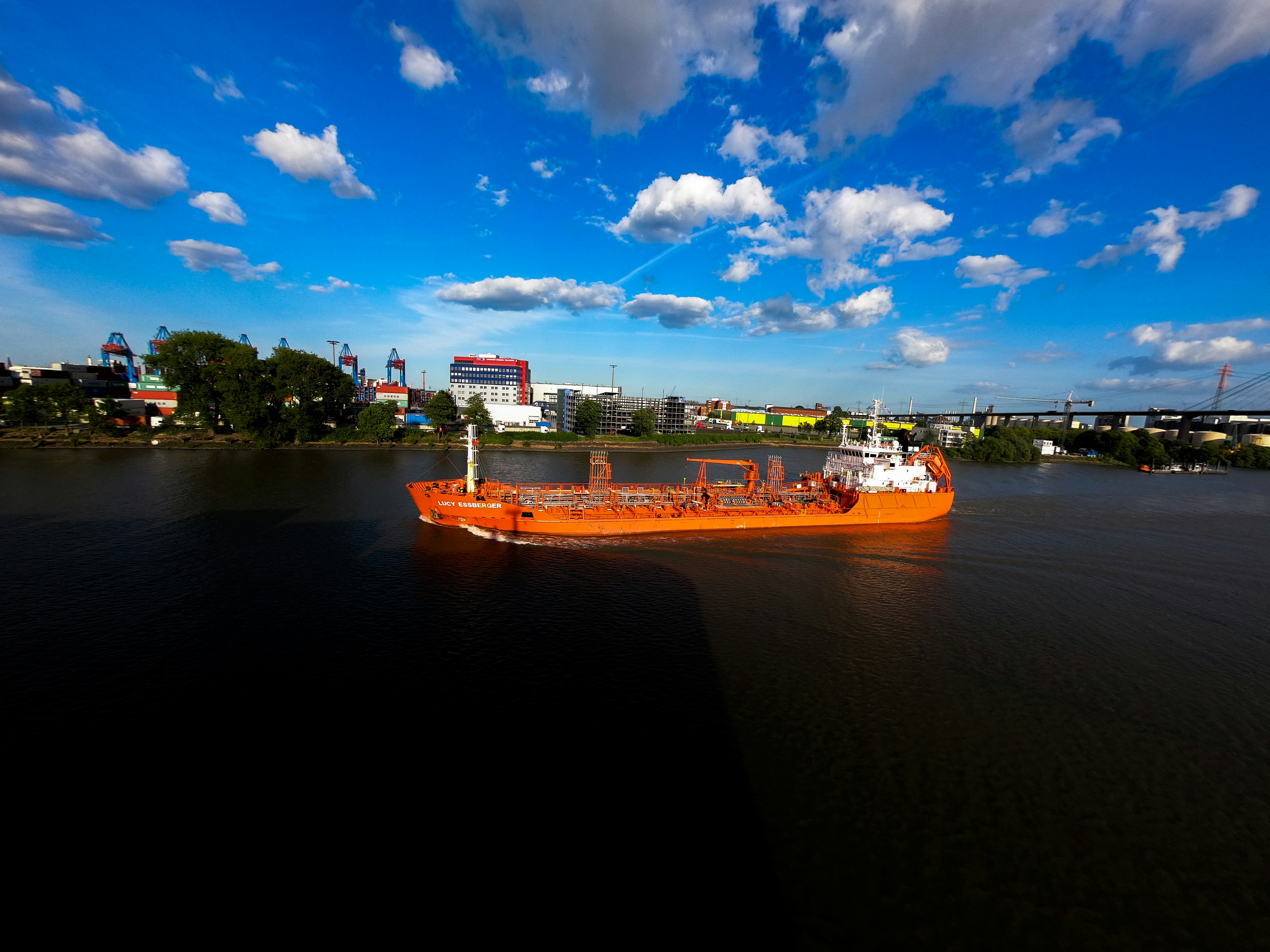 white and orange boat on water under blue sky during daytime