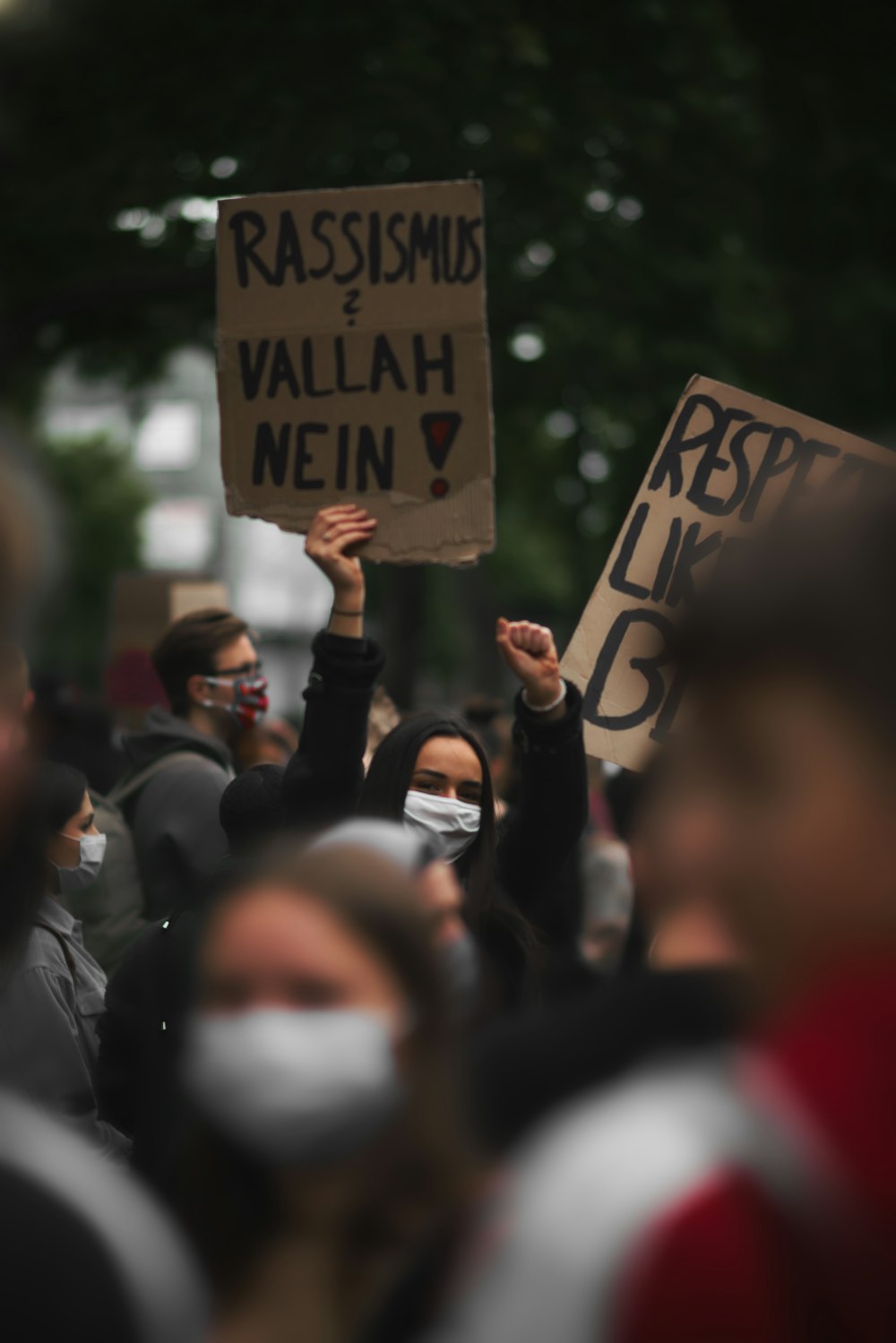 people holding white and black wooden signage