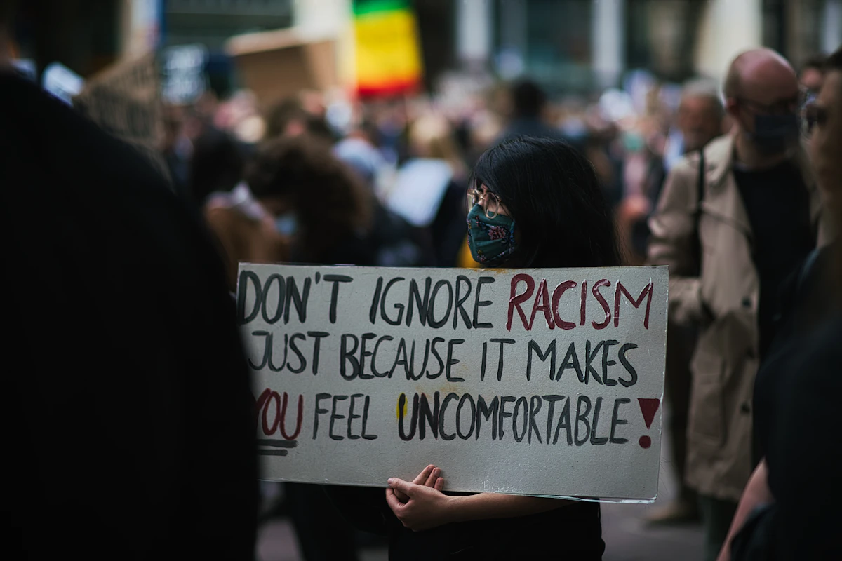 Person of color in a contemplative moment representing the psychological impact of racial trauma and the need for affirming mental health support