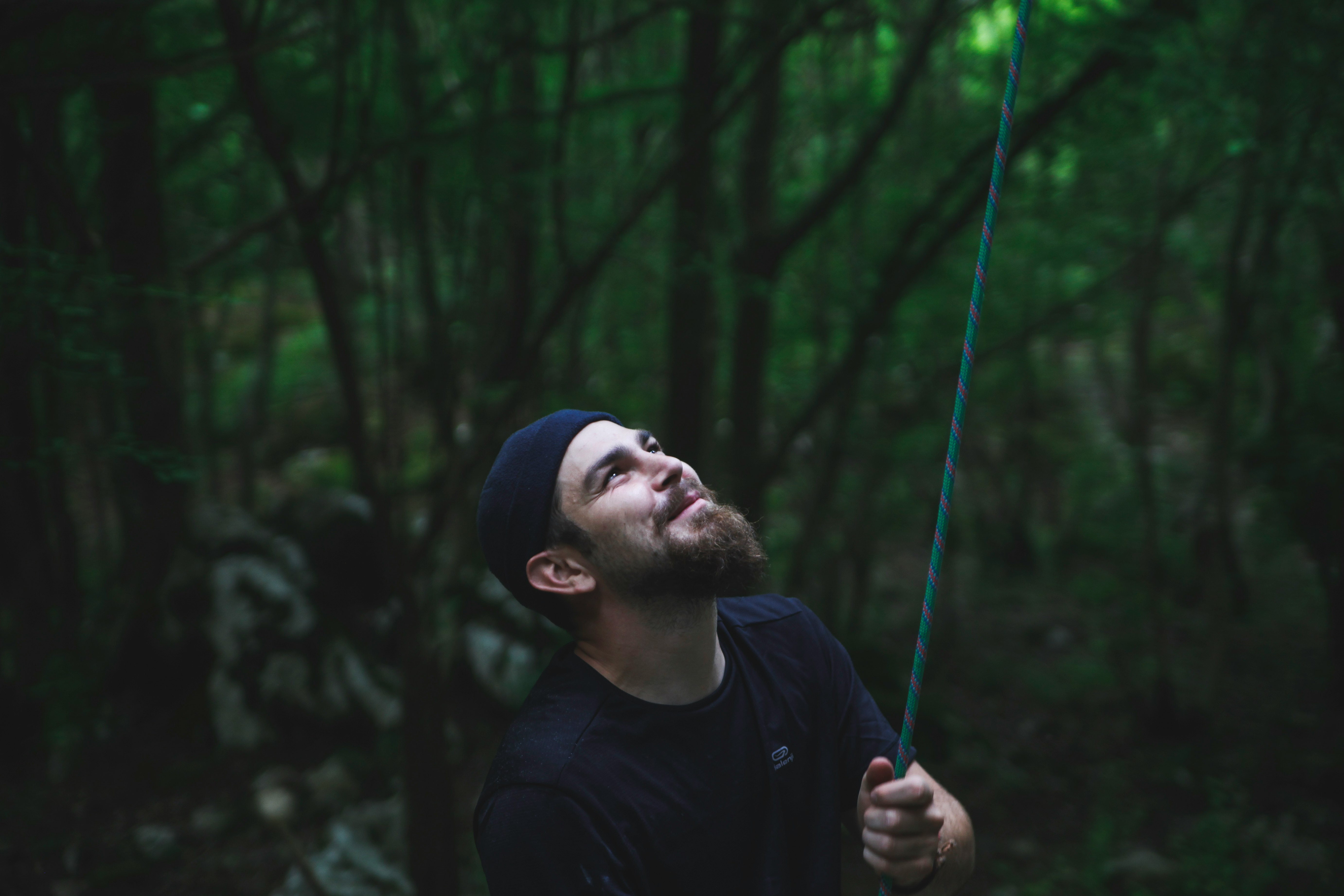 man in black crew neck shirt holding green rope