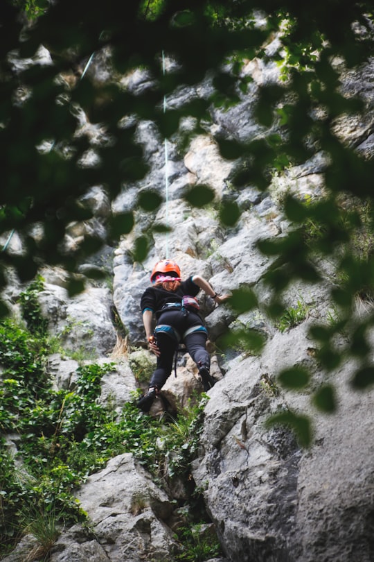 man in black t-shirt climbing on rocky mountain during daytime in Transylvania Romania