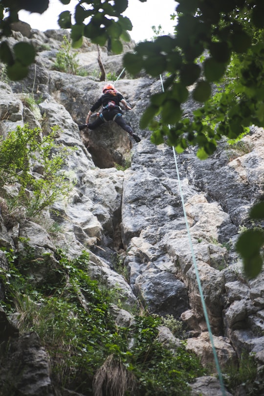 man in black jacket climbing on rocky mountain during daytime in Transylvania Romania