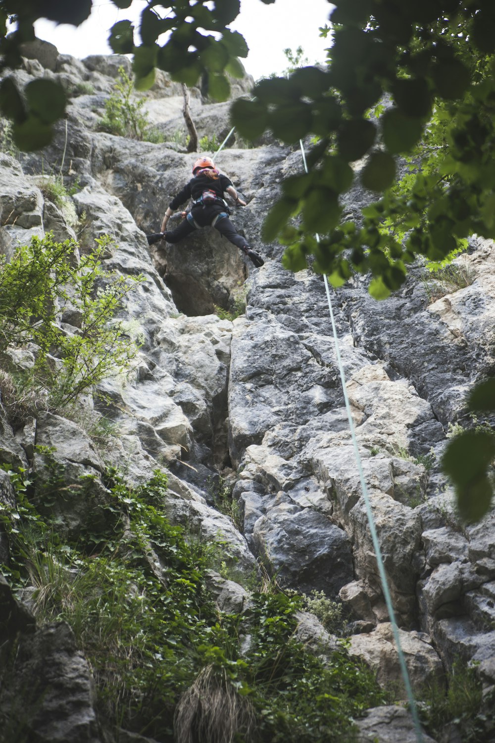 man in black jacket climbing on rocky mountain during daytime