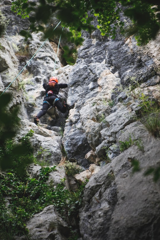 man in black jacket climbing on rocky mountain during daytime in Transylvania Romania