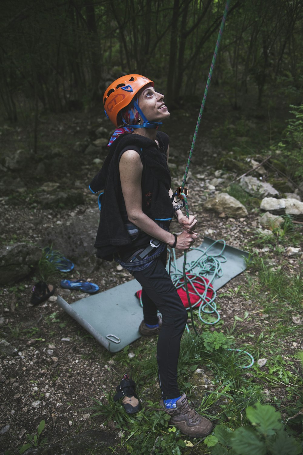 man in black tank top and orange helmet holding blue and red rope