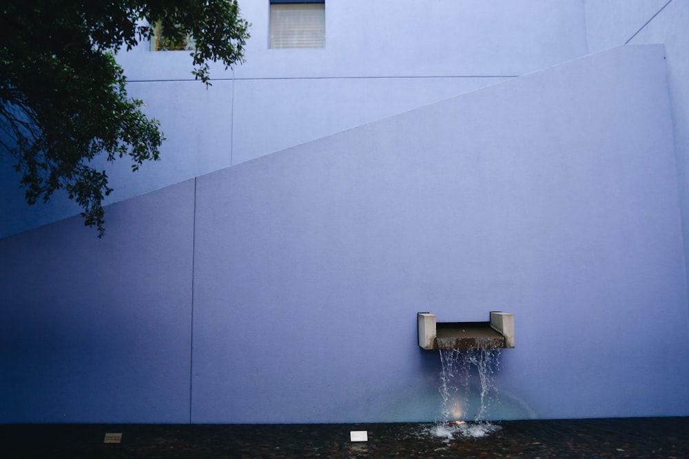fontaine d’eau près du mur blanc
