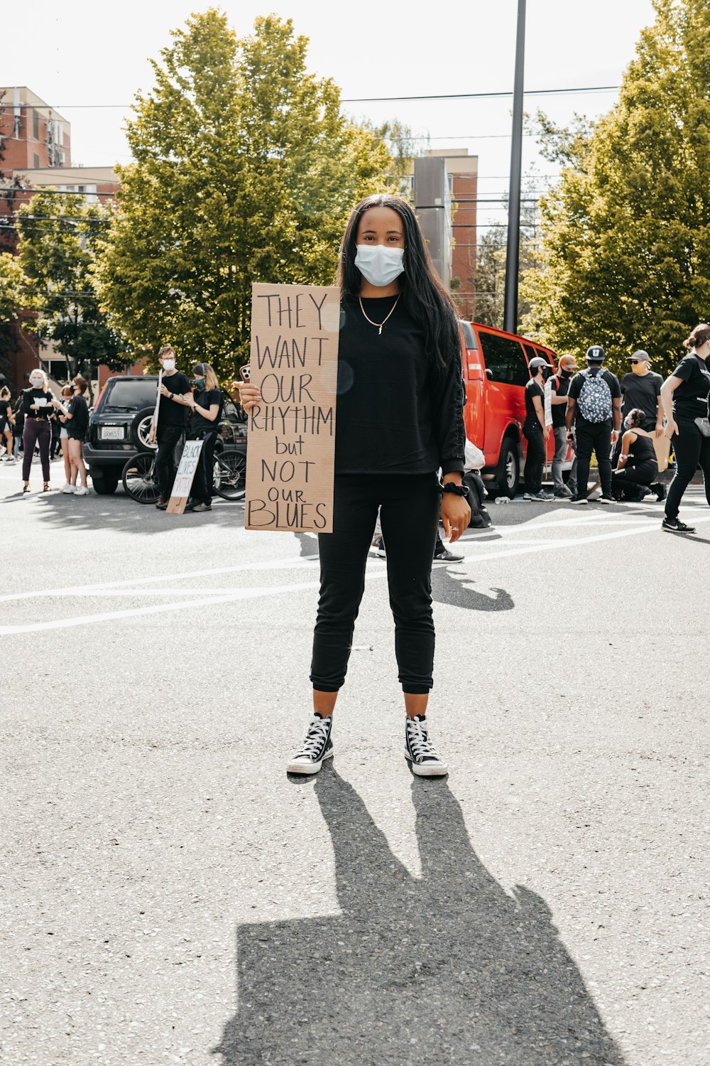 a woman wearing a face mask holding a sign