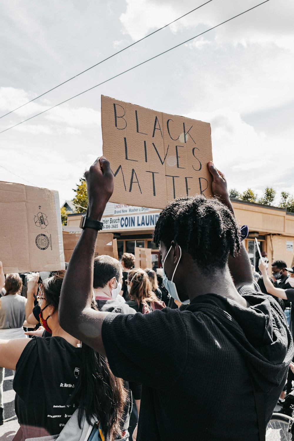 man in black t-shirt holding brown cardboard box