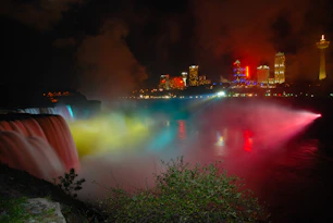 body of water near city buildings during night time