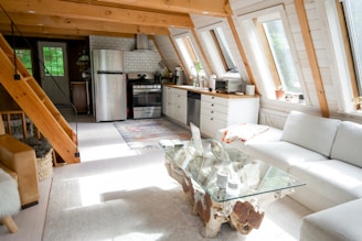 kitchen and living room with white cabinets, natural light, and modern vacation renta