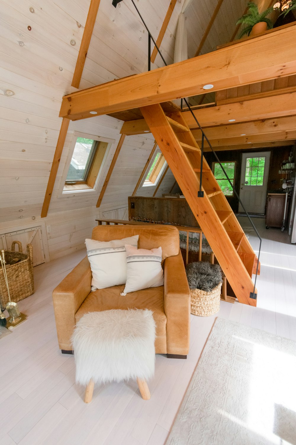 brown wooden staircase near white sofa