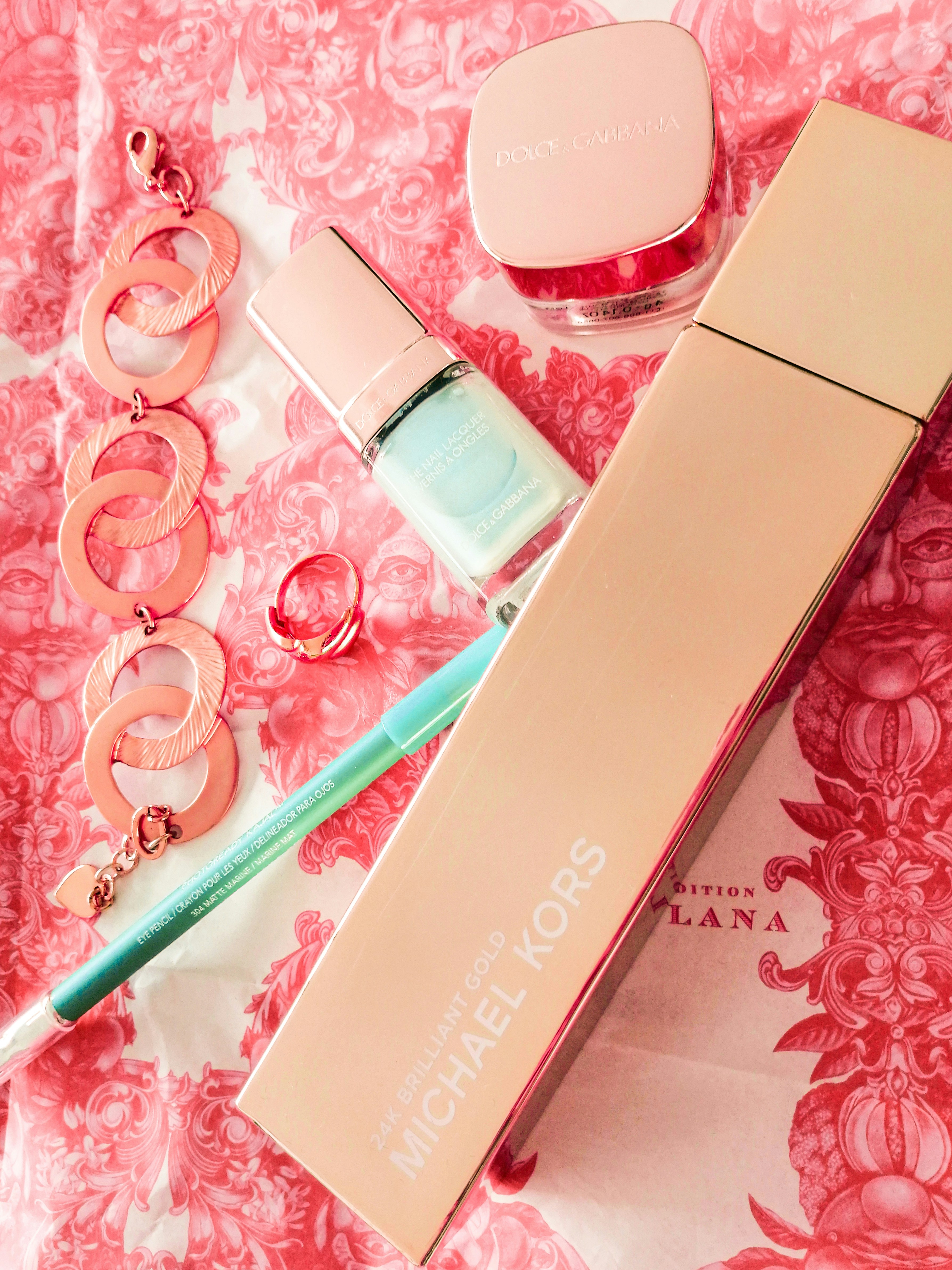 Luxury gold beauty products arranged elegantly on pink background