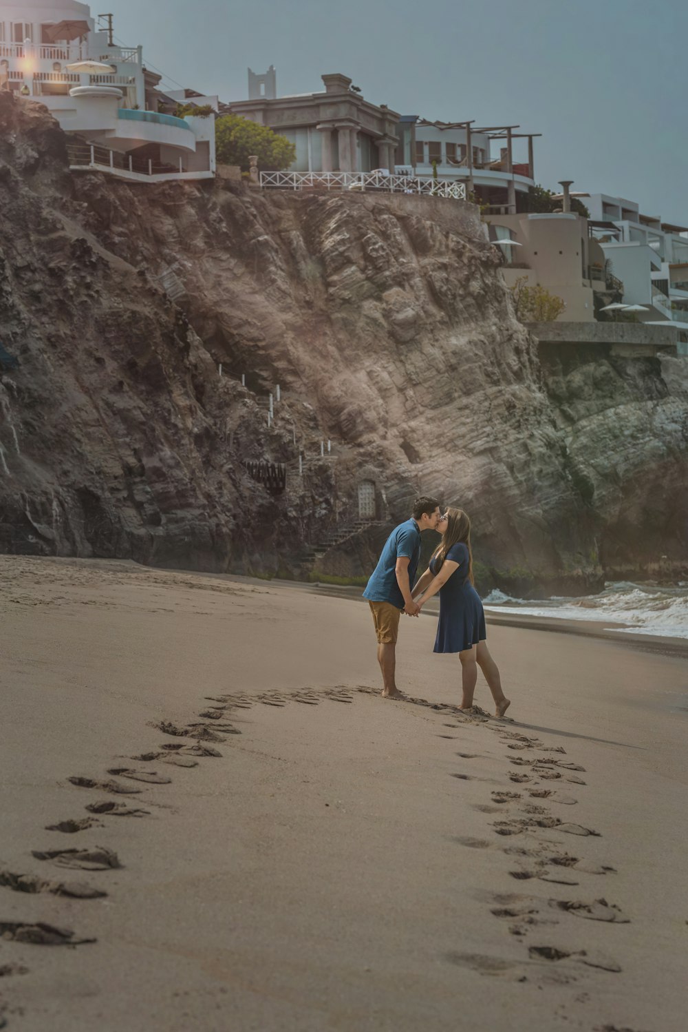 a man and a woman kissing on the beach