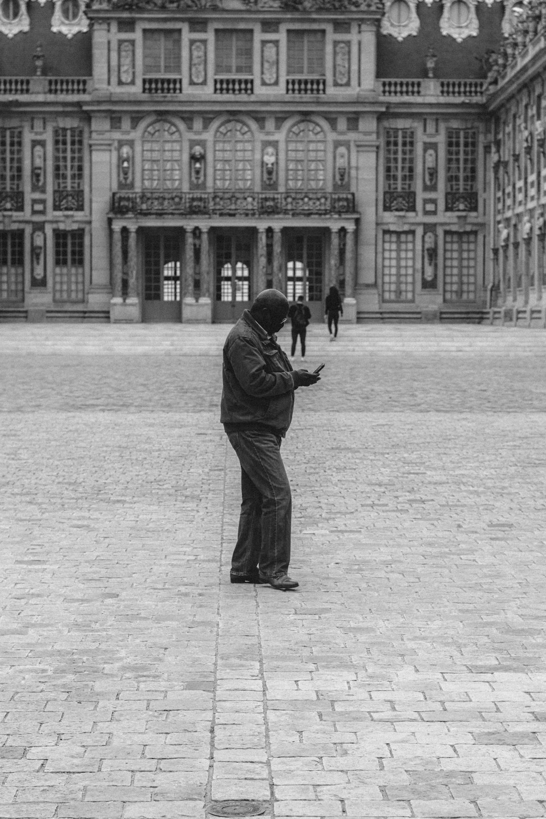 man in black jacket standing on gray concrete floor