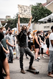 people holding white and black banner during daytime
