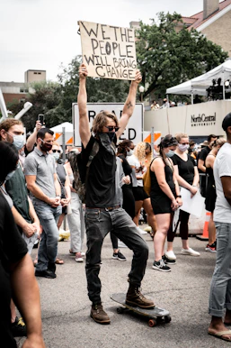 people holding white and black banner during daytime