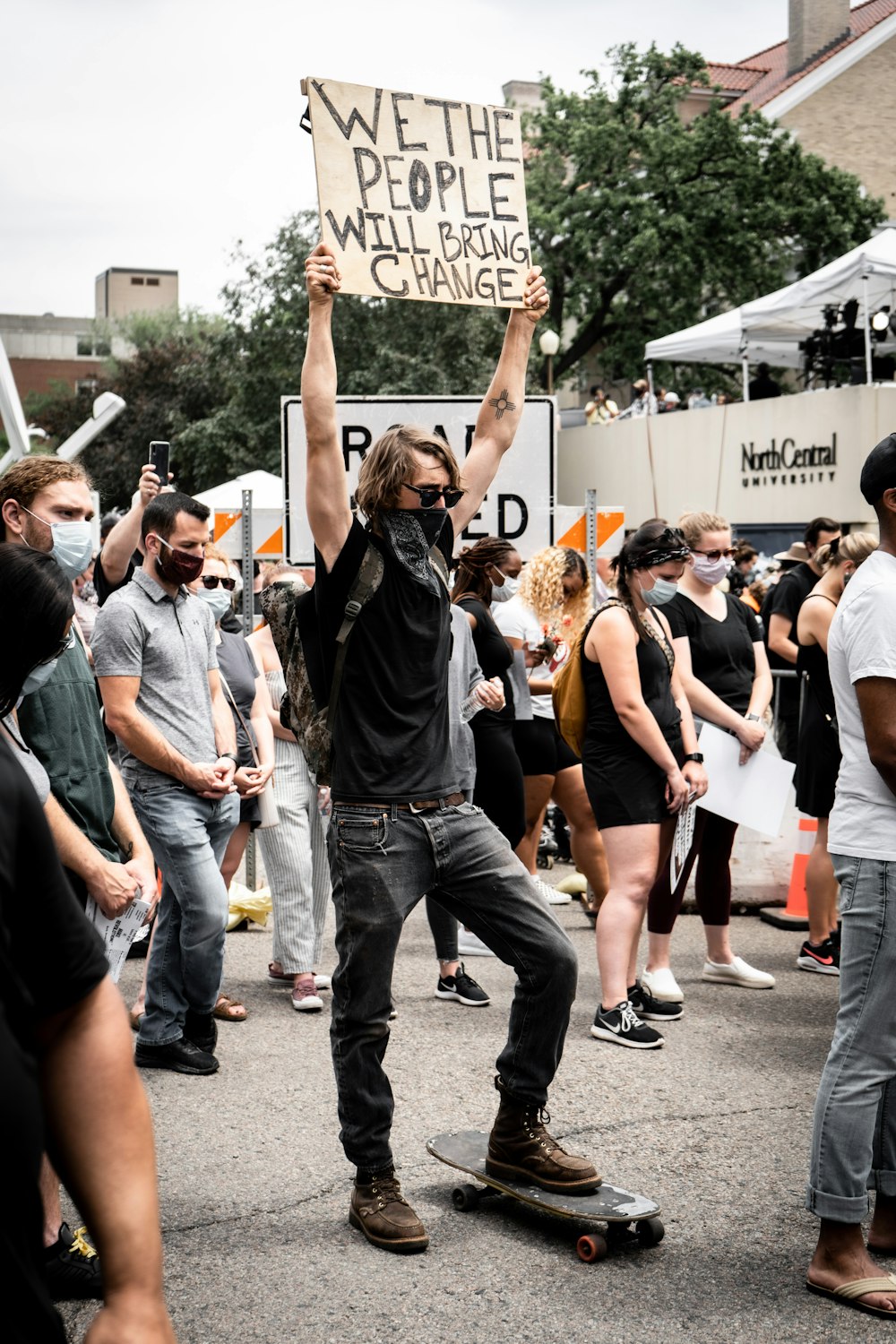 people holding white and black banner during daytime